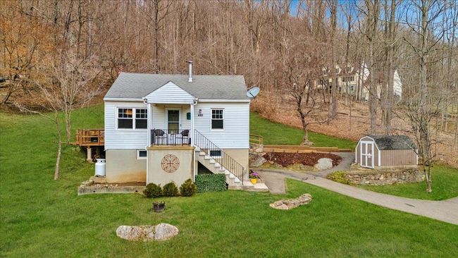 View of front of property featuring stairs, an outdoor structure, a front yard, and a shed | Image 26