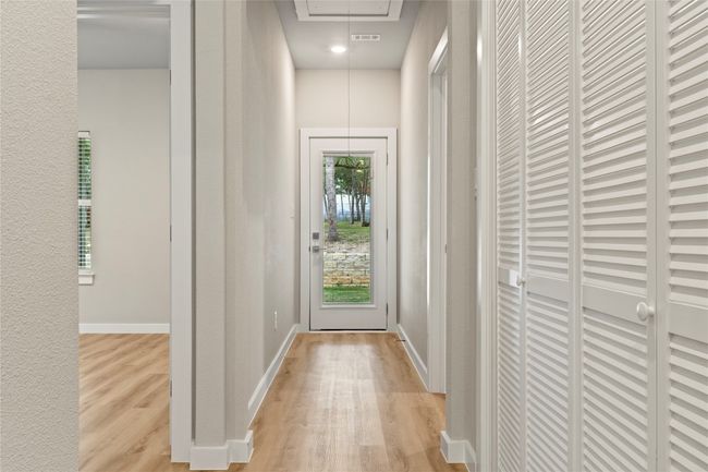 A spacious hallway leading to the bedrooms and a stunning covered patio with breathtaking backyard views. | Image 14