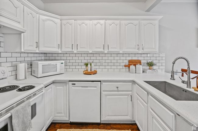 Kitchen featuring white cabinetry, white appliances, and sink | Image 4