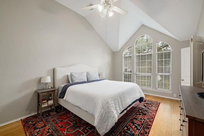 Primary Bedroom with lofted ceiling, light wood-style floors, a ceiling fan, and walk in closet | Image 7