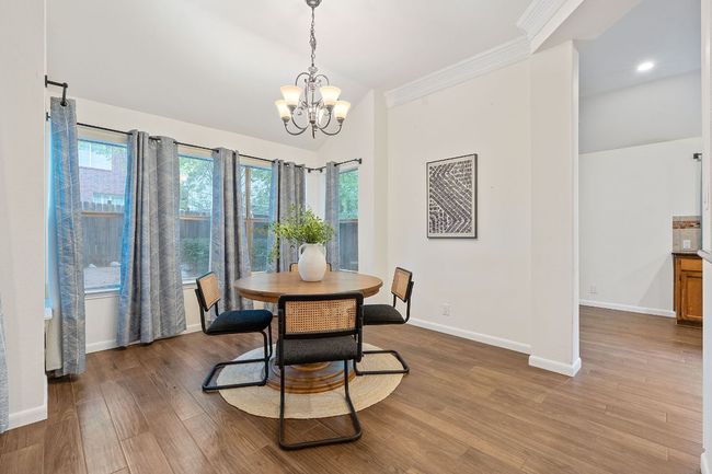 A spacious dining area sits along a wall of windows and opens beautifully to the kitchen and living room, perfect for entertaining. | Image 12
