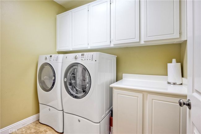 Second level laundry room provides much more room than most, convenient cabinetry and a folding counter. There is also a large step-in storage closet with doors, excellent for extra storage! (See photo of this on virtual tour) | Image 22