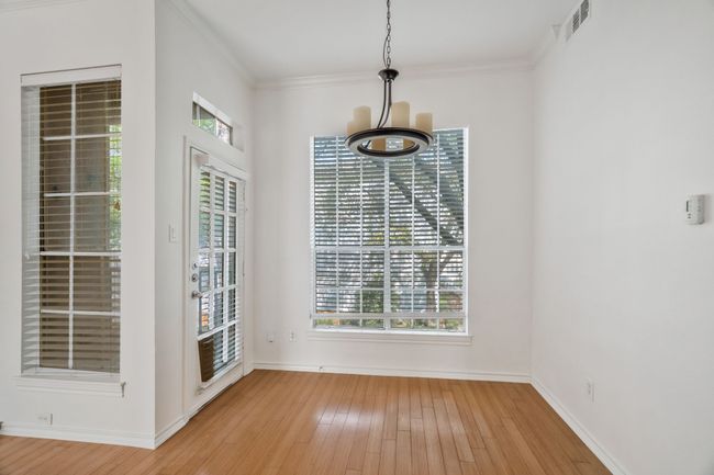Unfurnished dining area with light wood-type flooring, baseboards, ornamental molding, and visible vents | Image 7