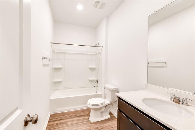 Full bathroom featuring vanity, toilet, wood finished floors, bathing tub / shower combination, and baseboards | Image 22