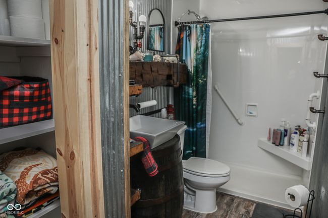 full bath featuring toilet, a shower with curtain, and wood finished floors | Image 9