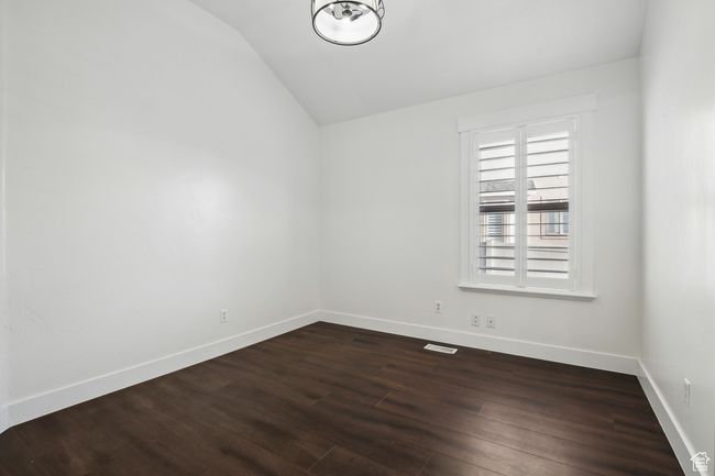 Unfurnished bedroom room with lofted ceiling and dark hardwood / wood-style floors | Image 20