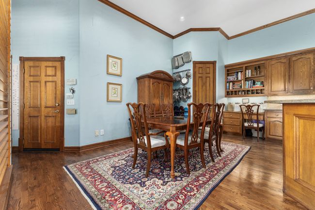 Dining space featuring high vaulted ceiling, wood-style flooring, and crown molding | Image 8