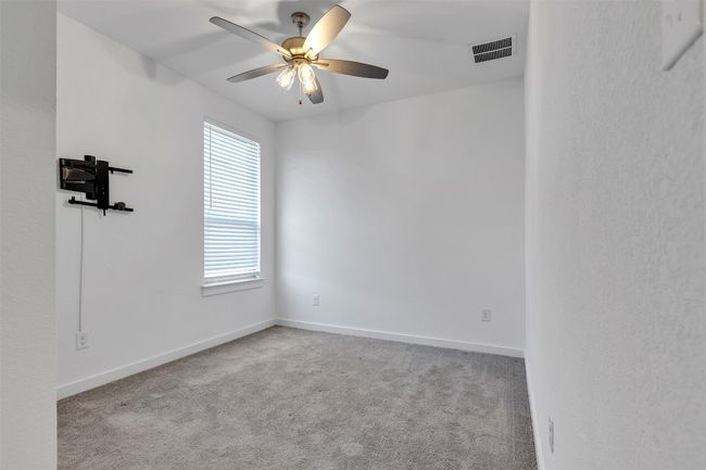 Carpeted spare room featuring a ceiling fan and baseboards | Image 8
