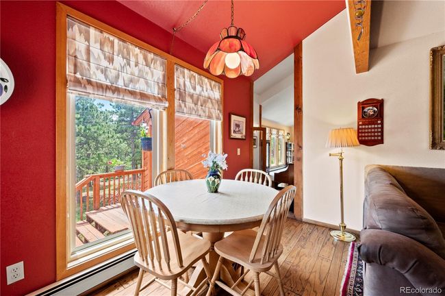 Kitchen eating area with windows and door out to the front deck and yard.. | Image 11