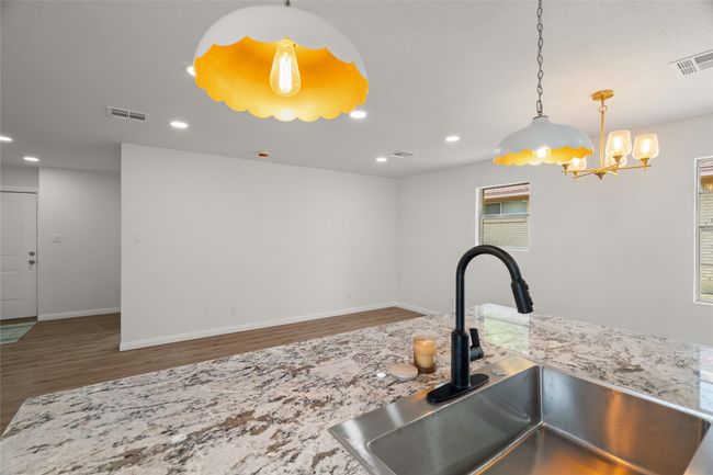 Kitchen featuring a sink, wood finished floors, a chandelier, recessed lighting, and baseboards | Image 10