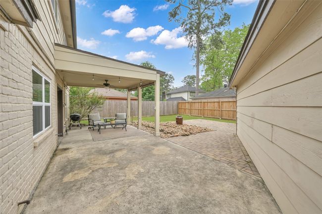 The covered patio extends with more patio and the additional brick paver patio. | Image 26