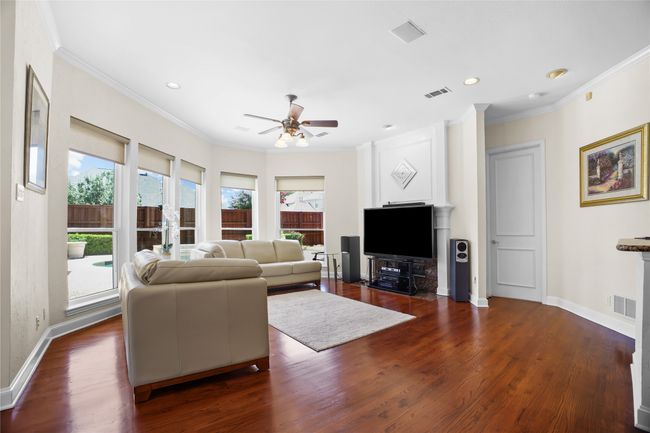 Living area featuring ceiling fan, crown molding, wood finished floors, and recessed lighting | Image 12