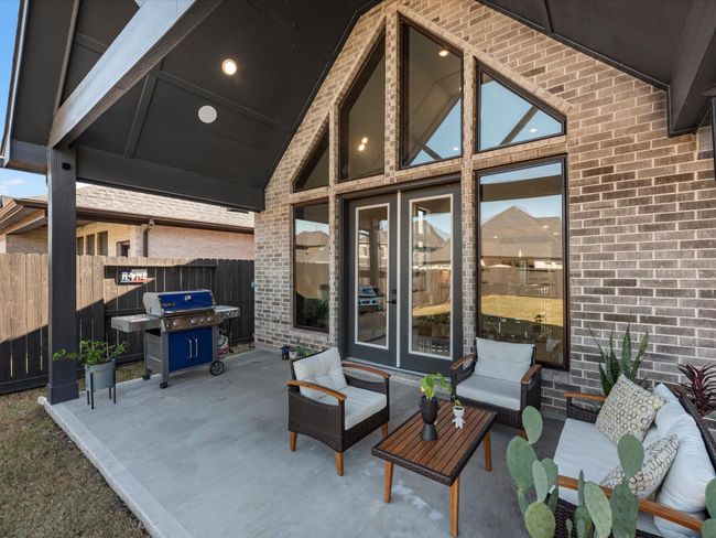 enjoy cozy nights with friends in this beautiful extended patio with a huge yard with sprinklers system for easy care. | Image 32