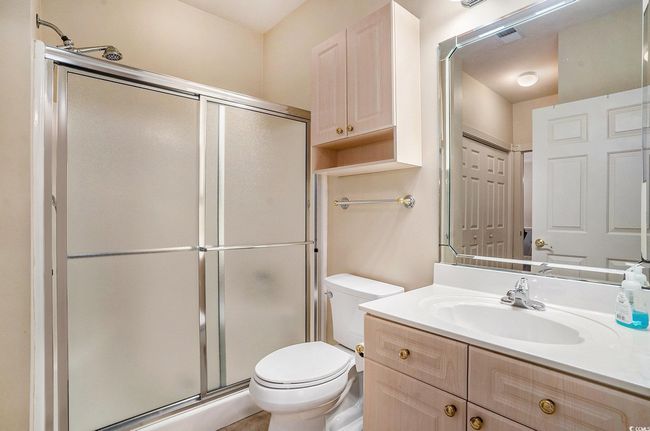 Bathroom featuring a stall shower, toilet, and vanity | Image 13