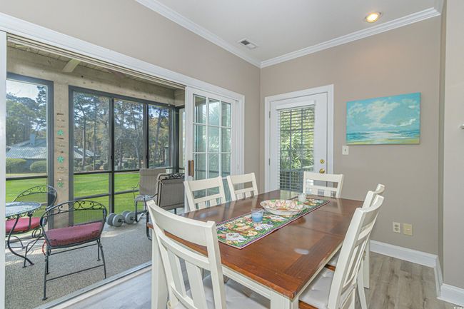 Dining area with baseboards, visible vents, crown molding, and wood finished floors | Image 6