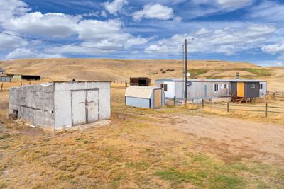 View of yard with a mountain view, a shed, and a rural view | Image 1