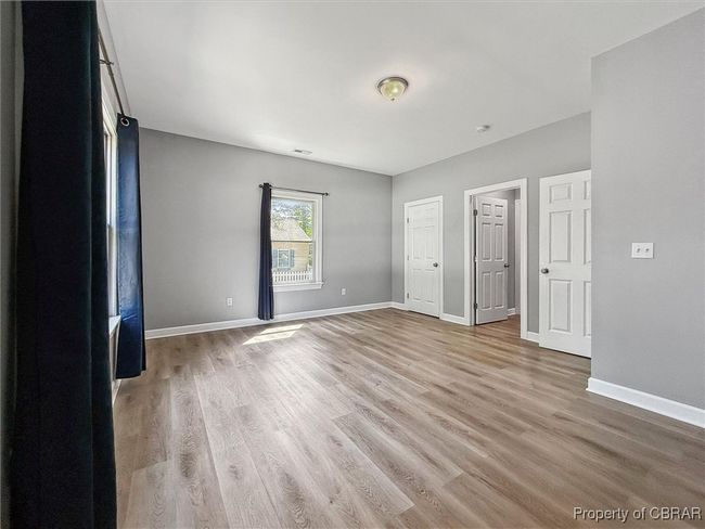 Unfurnished bedroom with light wood-style flooring and baseboards | Image 22
