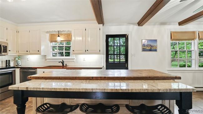 Kitchen with appliances with stainless steel finishes, healthy amount of natural light, beamed ceiling, tasteful backsplash, and a center island | Image 42