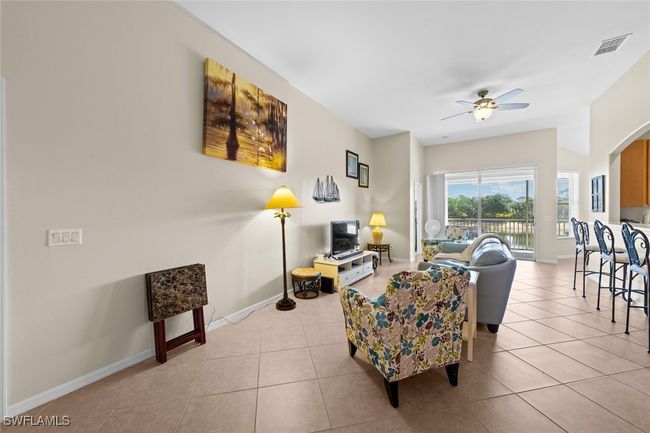 Living area with ceiling fan, baseboards, light tile patterned flooring, and visible vents | Image 18