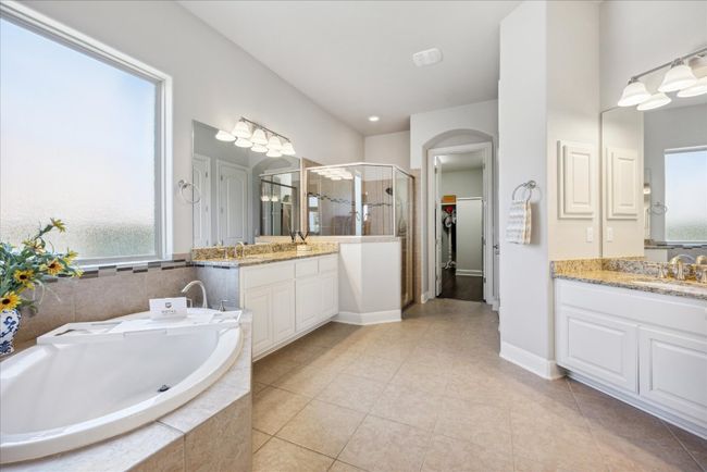 Bathroom with tile patterned floors, a sink, a stall shower, two vanities, and a bath | Image 15