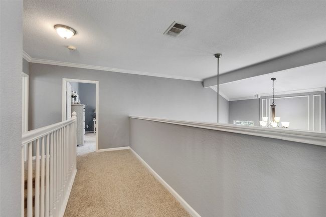 Corridor featuring a chandelier, carpet floors, baseboards, crown molding, and an upstairs landing | Image 19