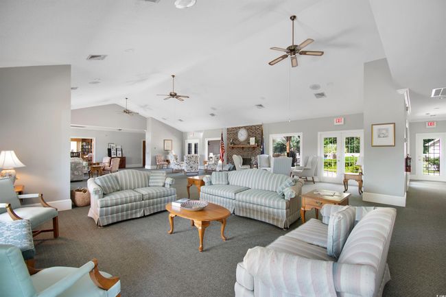 Carpeted living room with a ceiling fan and high vaulted ceiling | Image 33