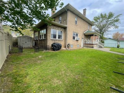 View of side of property featuring cooling unit, a yard, and a shed | Image 2