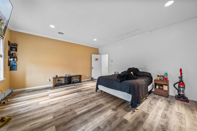 Bedroom featuring baseboards, recessed lighting, crown molding, visible vents, and wood finished floors | Image 19