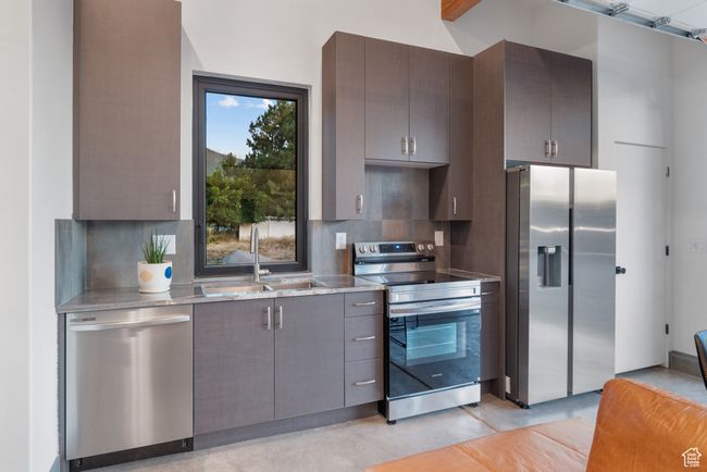 Kitchen featuring appliances with stainless steel finishes, tasteful backsplash, light stone countertops, and gray cabinets | Image 76