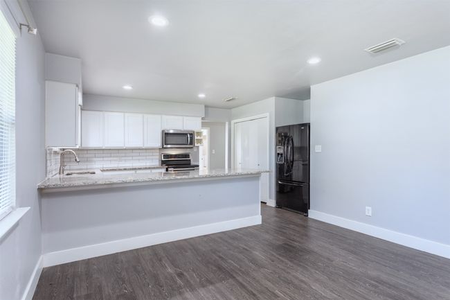 Kitchen featuring a sink, baseboards, visible vents, light stone countertops, and appliances with stainless steel finishes | Image 8