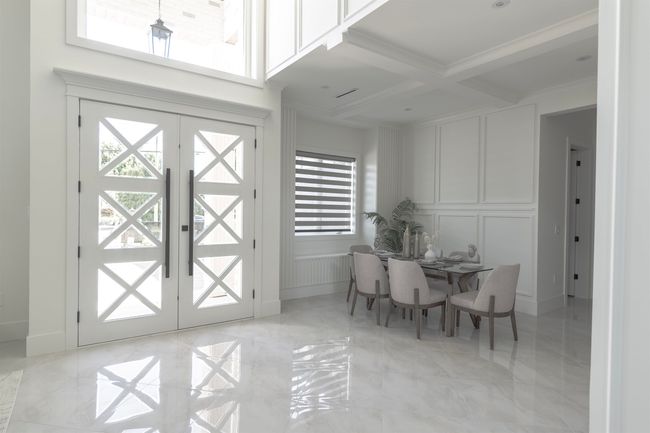 Dining room with a decorative wall, french doors, beamed ceiling, light marble finish flooring, and coffered ceiling | Image 5