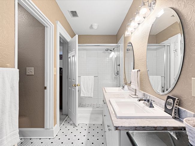 Bathroom with tile patterned flooring, a stall shower, visible vents, and a sink | Image 27