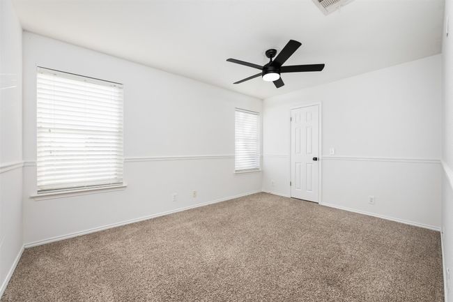 Empty room with carpet flooring, ceiling fan, baseboards, and a wealth of natural light | Image 33