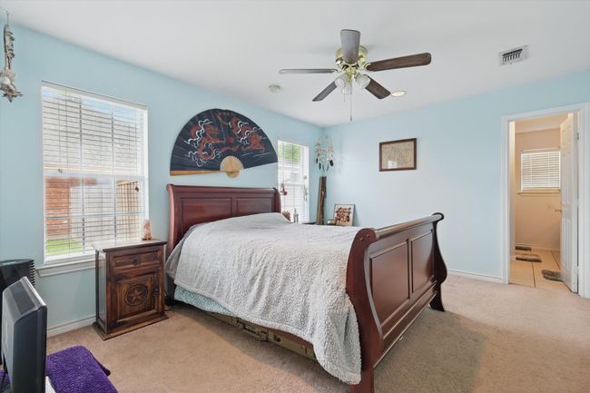 Bedroom with ceiling fan, light colored carpet, baseboards, and visible vents | Image 21