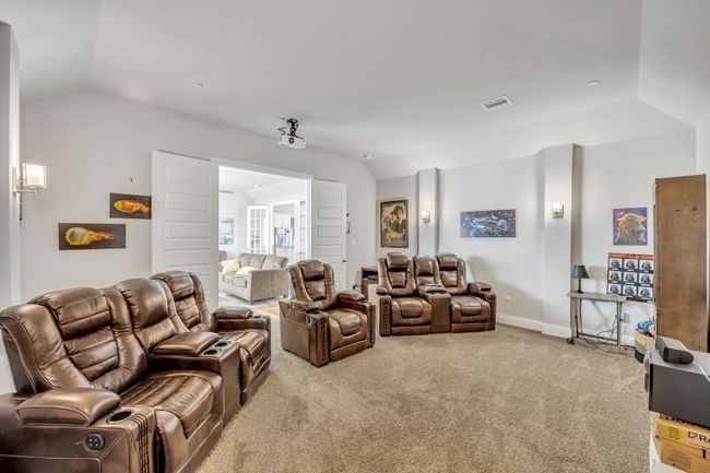 Carpeted home theater room with lofted ceiling | Image 15