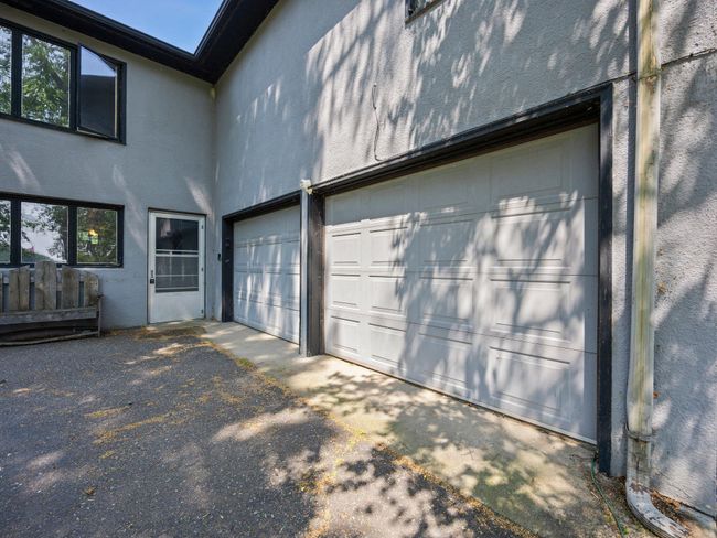 From here, access the attached two-car garage, which includes built-in shelving, a workbench area, and a remote-controlled opener. | Image 11