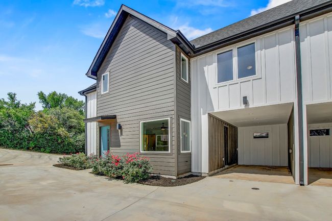 View of side of home featuring board and batten siding, a carport, concrete driveway, and roof with shingles | Image 30