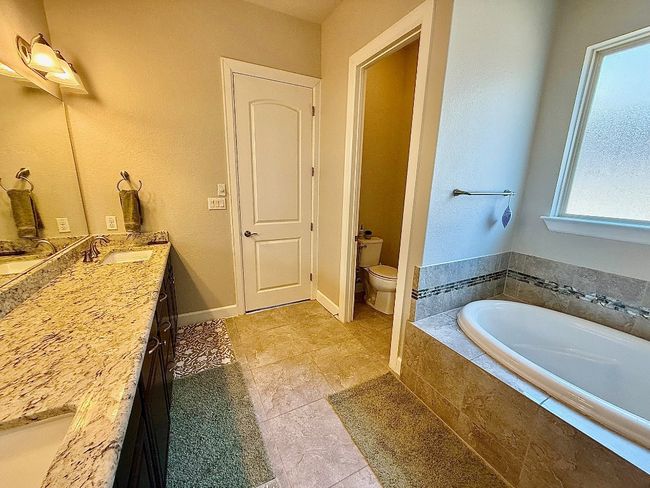 Full bath featuring vanity, a bath, toilet, and tile patterned floors | Image 13