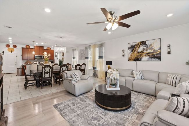Living room featuring recessed lighting, ceiling fan, a chandelier, light wood-type flooring, and crown molding | Image 15
