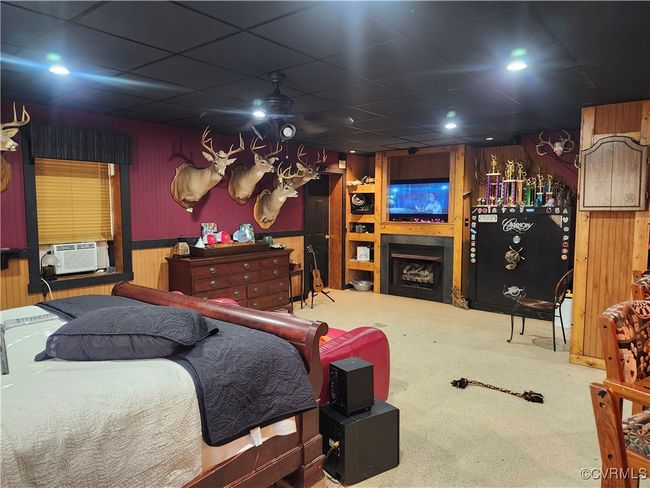 featuring cooling, Gas logs unit, wood Walls, a fireplace, and a drop ceiling | Image 15