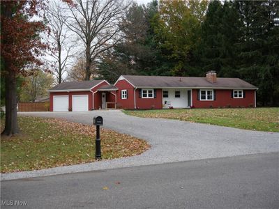 Ranch-style home featuring a front lawn and a garage | Image 1