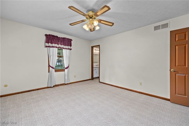 Carpeted primary bedroom with access to ensuite bathroom | Image 19