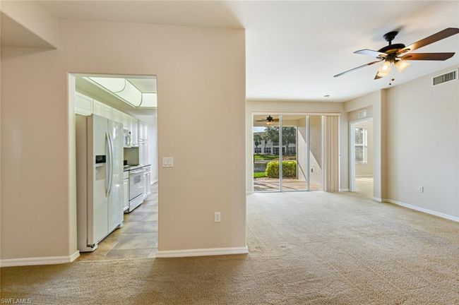 Spare room featuring a ceiling fan, baseboards, light colored carpet, and visible vents | Image 16