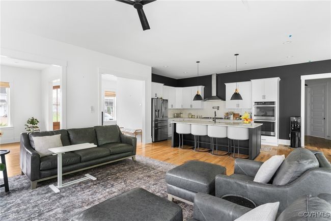 Living room featuring light wood finished floors and ceiling fan | Image 9