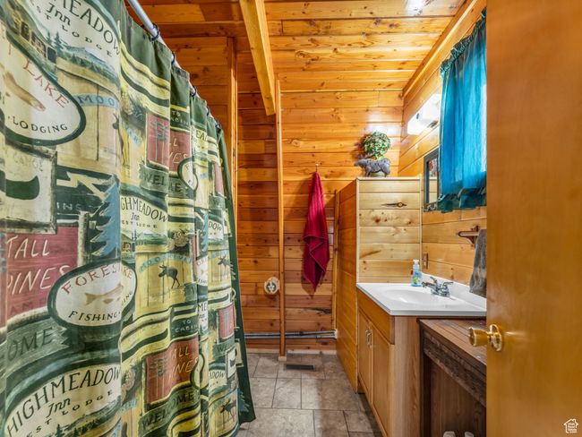 Bathroom with vanity, wood ceiling, wood walls, and a shower with shower curtain | Image 14