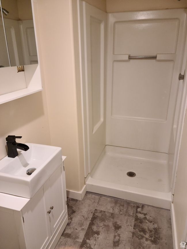 Full bath featuring a shower stall, vanity, and baseboards | Image 25