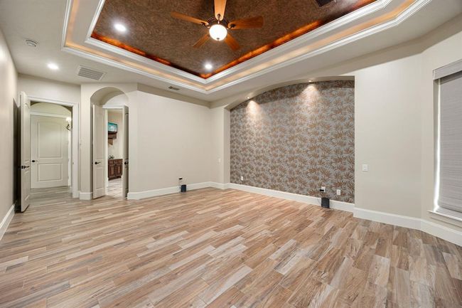 Another view of the primary bedroom with a view of the ensuite bathroom retreat. | Image 20