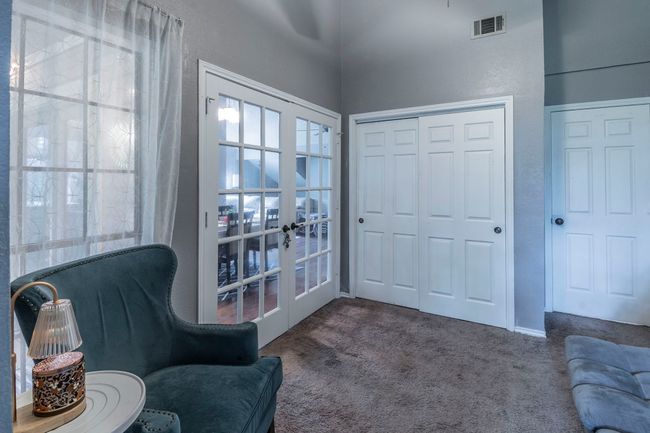 Bedroom with french doors that open to the dining room. The window looks out to the screened in balcony | Image 19