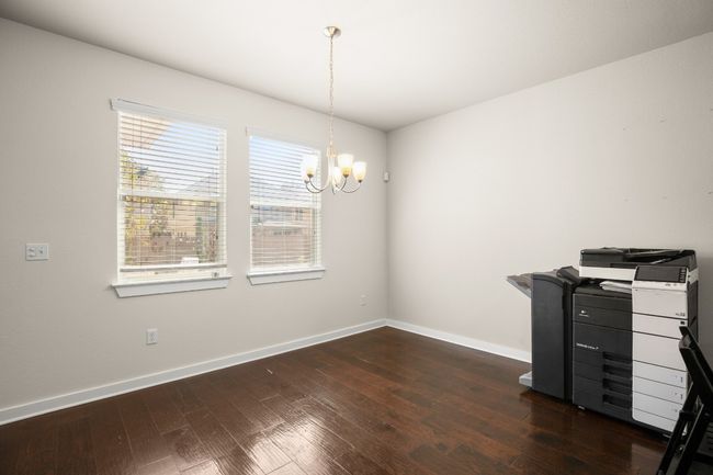 Large windows frame the room, offering serene views of the landscaped front yard. | Image 9