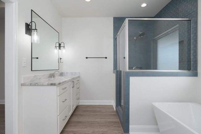 Bathroom featuring a shower stall, a soaking tub, wood finished floors, and vanity | Image 22